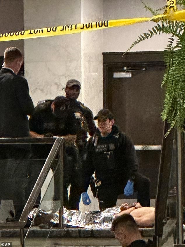 Allen is seen wrapped in a foil blanket on a stretcher after investigators say he unleashed a hail of bullets. He was taken to the hospital for a medical check but appeared unharmed, police said