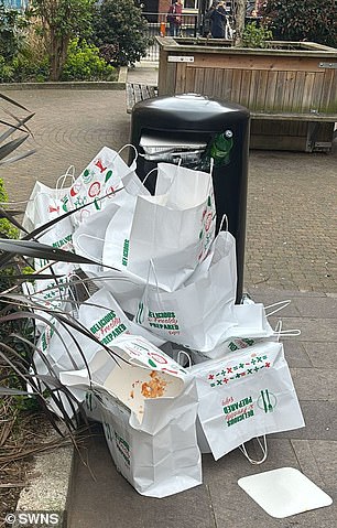 Multiple bags from the kebab shop are littered on the ground next to a nearby bin