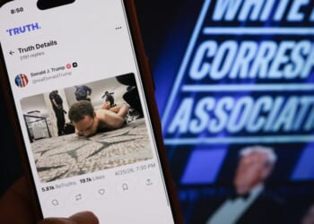 Someone holds a phone with a picture of a post published by President Donald Trump on Truth Social showing the alleged shooter accused of opening fire at the White House Correspondents' dinner in Washington, DC on April 25, 2026.
