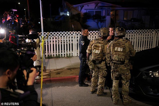 Police officers and FBI agents stand in front of the media gathered outside Allen's home