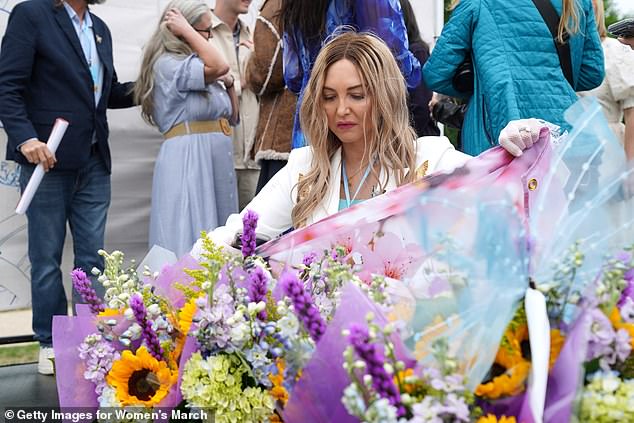 Another Epstein survivor Lara Blume-McGee attends to flowers at the vigil