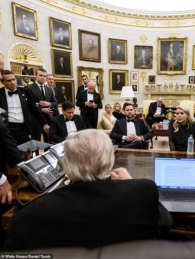 Trump at the Resolute Desk at the White House surrounded by his cabinet and top staff
