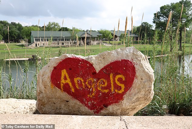 A giant  painted rock reading 'Angels' stands outside the camp in memory of the victims