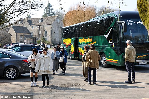 Coaches bring tourists to Bibury in Gloucestershire which is a popular village in the Cotswolds