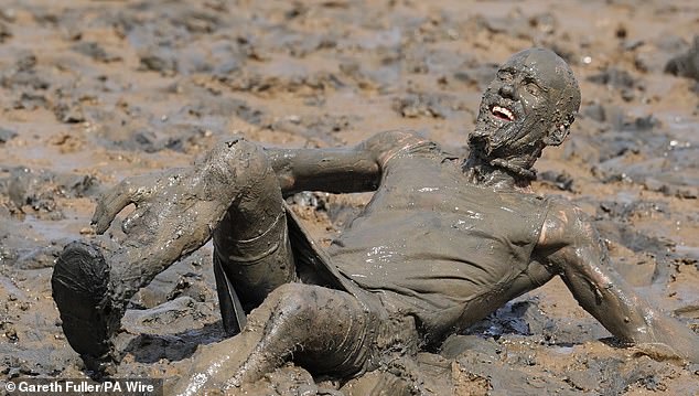 A man becomes completely drenched in mud after he seemingly slipped in the drained river bed