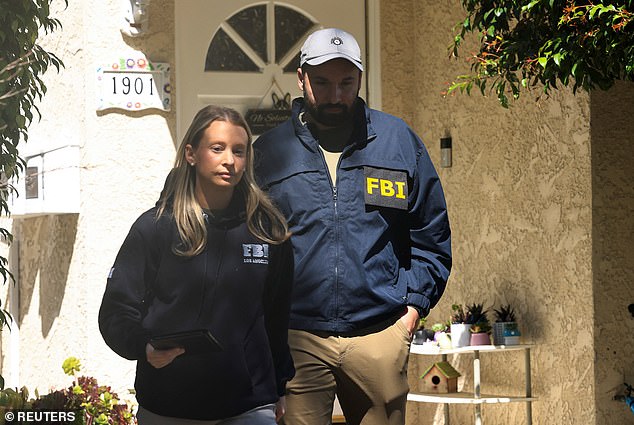 Members of the FBI walk to inspect the neighbourhood where the house associated with Cole Tomas Allen