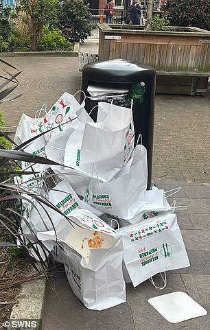 Multiple bags from the kebab shop are littered on the ground next to a nearby bin