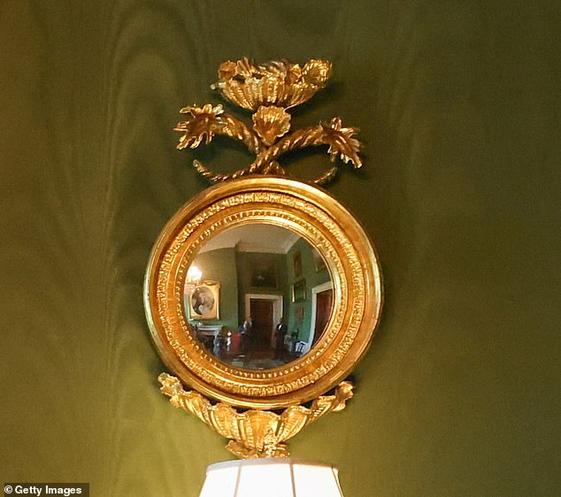 The security detail can be glimpsed in the mirrors of the Green Room