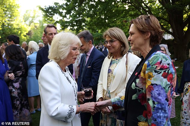 Queen Camilla mingling with guests at a lavish garden party hosted at the British Embassy