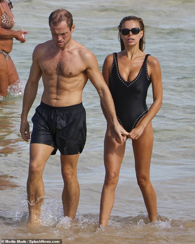 Taron opted for navy swimming shorts rather than tight briefs, showing off his incredibly ripped torso as he went shirtless for the dip