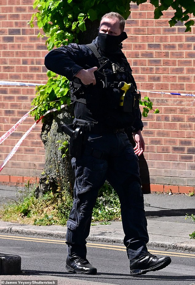 An armed policeman at the scene of the stabbings, which happened at around 11.45am
