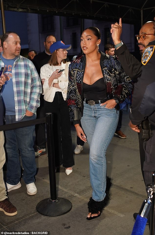 Jenner's former best friend, Jordyn Woods, arrives at the game in a black bustier, blue jeans and a trendy leather jacket. Woods is engaged to Knicks star Karl-Anthony Towns