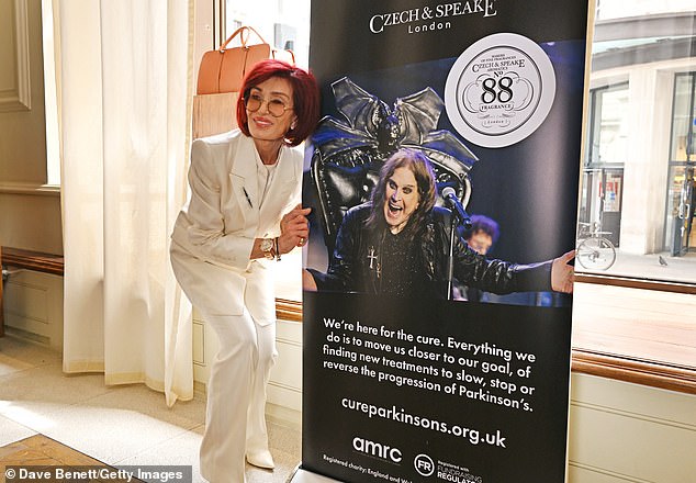 The star, 73, posed beside a photo of the legendary rocker before leaning in to give him a peck in sweet snaps