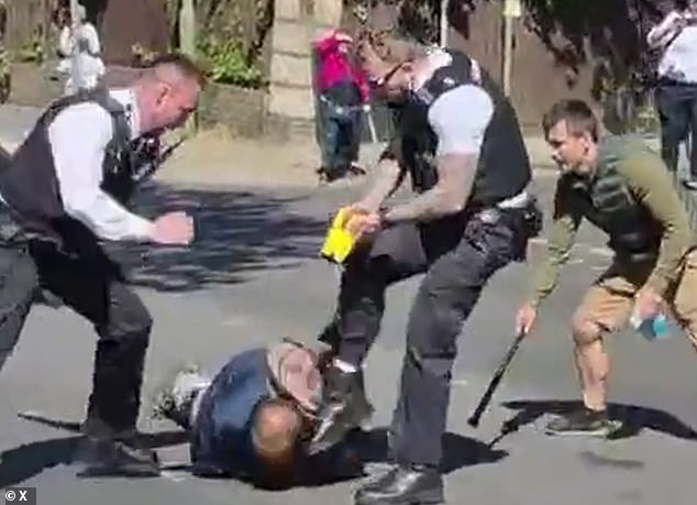 Officers kick the suspect in the head after Tasering him while shouting 'drop the knife'. They were helped by a passer-by (right)