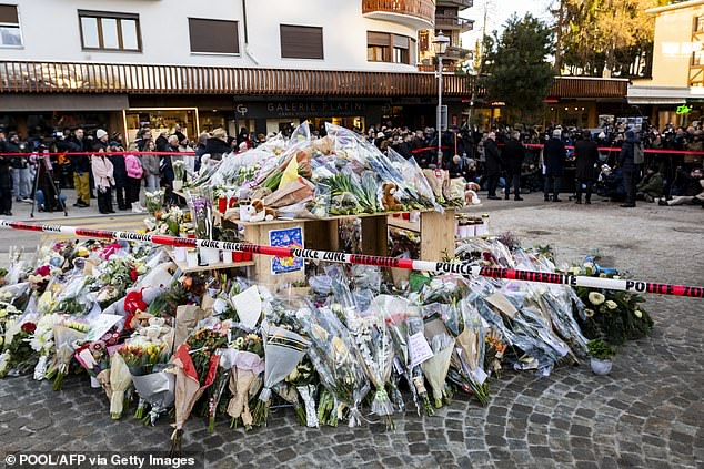 Flowers and candles in tribute to the victims are displayed at a makeshift memorial following a fire at 'Le Constellation' bar during New Year's Eve celebrations on January 3, 2026