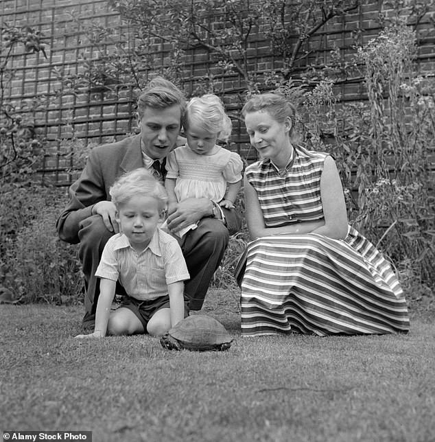 A young David Attenborough pictured in the back garden of the house he still lives in shortly after moving in, pictured with his late wife Jane and children Robert and Susan