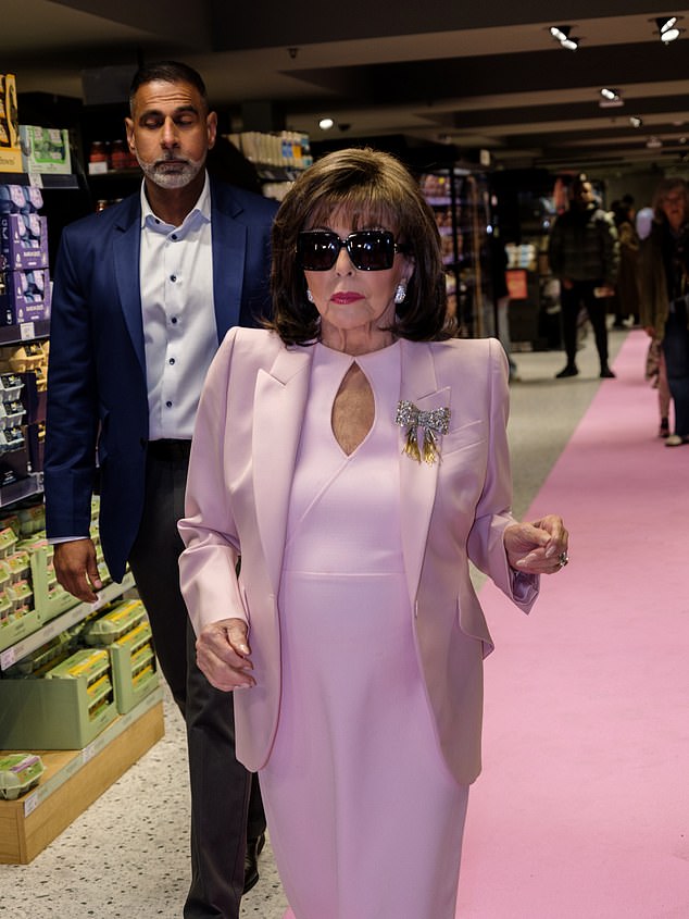 Joan oozed elegance in the pink jacket and dress combo, on which she upped the glam with a dazzling diamond brooch in the shape of a bow