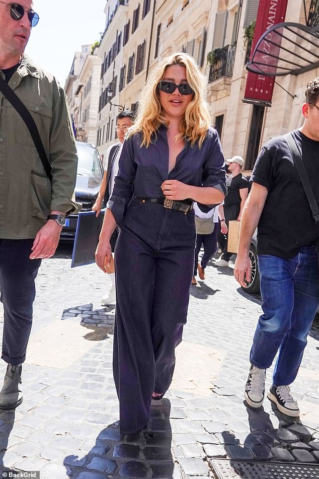 She completed her second ensemble with a pair of large black-tinted sunglasses and a leather bel