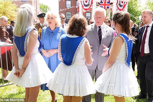 Charles and Camilla speak with local cheerleaders at the event