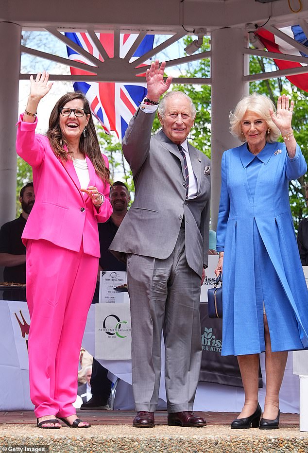 Charles and Camilla and Mayor of Front Royal, Lori Athey Cockrell watch and wave during a parade and community block party