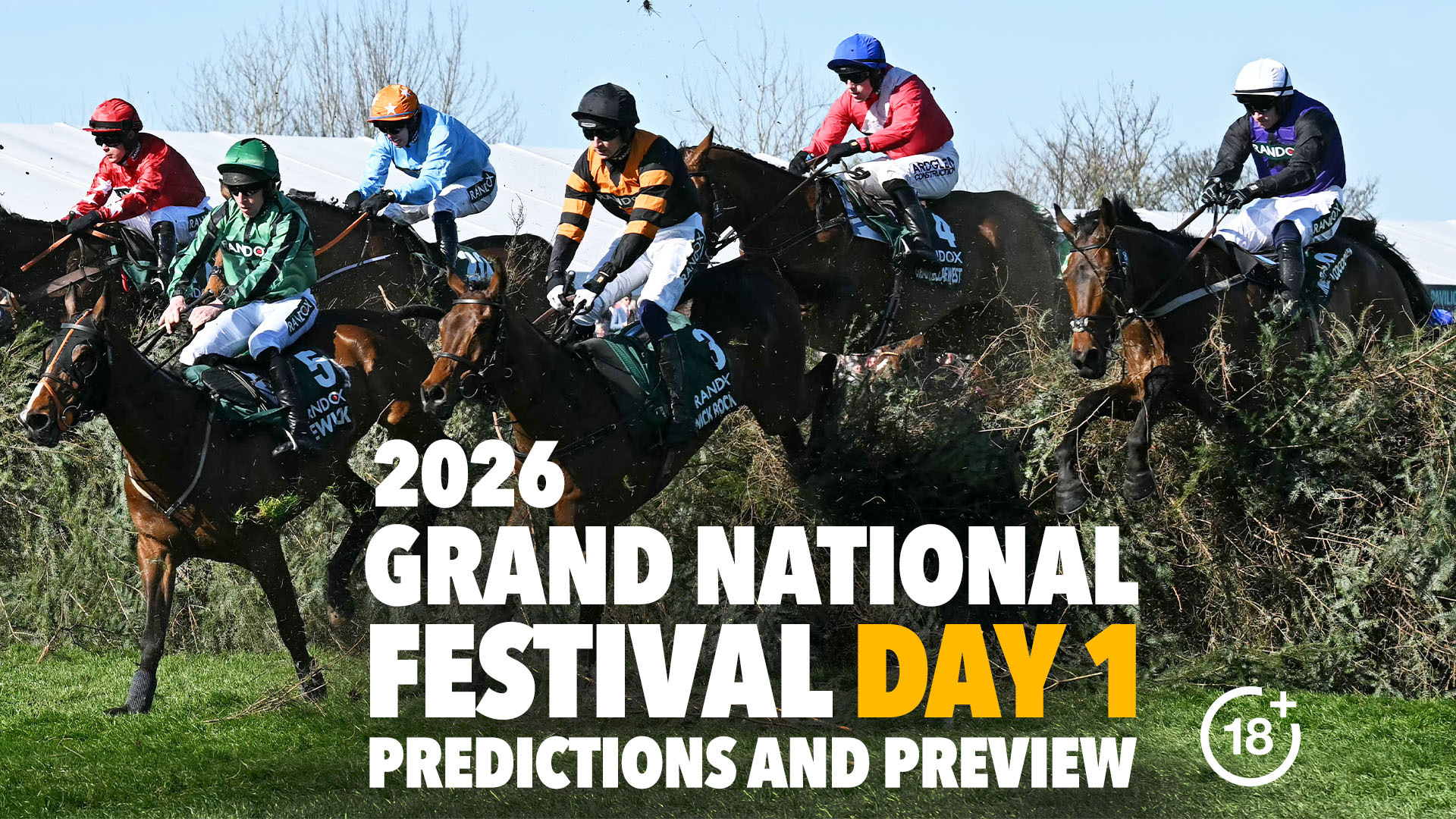 Racehorses and jockeys jumping over a hurdle at the Grand National Festival.