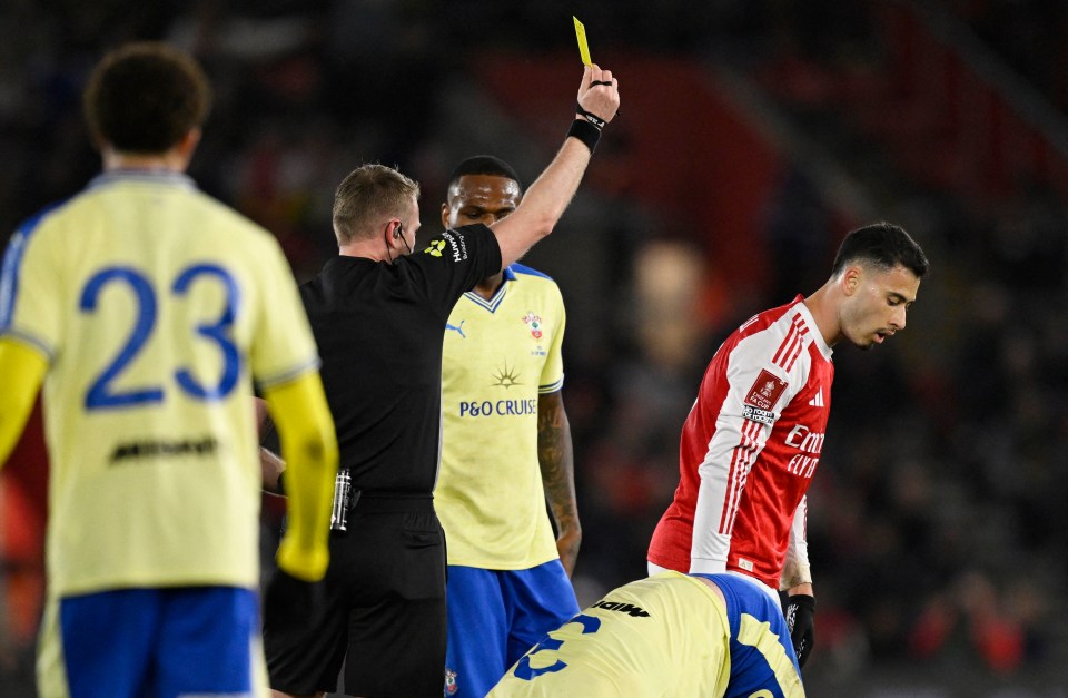 Referee Samuel Barrott shows Arsenal's Gabriel Martinelli a yellow card during an FA Cup quarter-final match.