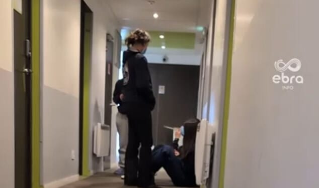 Students from a British private school are among nearly two hundred youngsters hit by 'severe' food poisoning at a French ski resort. Pictured: Children with facemasks sit in a hallway inside the holiday centre where scores of students have fallen in