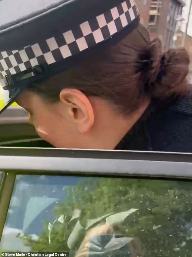 An officer shouts at Mr Maile as he is put in the police car: ¿In the name of Jesus, get in the car¿