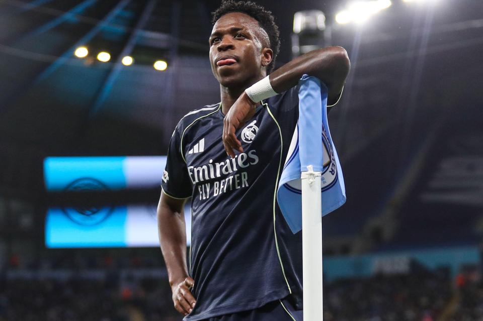 Vinicius Junior of Real Madrid resting his arm on a corner flag during a match.