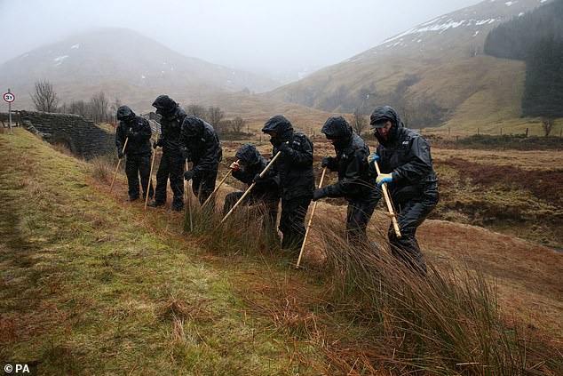 Police officers search undergrowth in a valley on the outskirts of Tyndrum looking for Tony Parsons