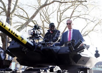 Derek Chisora (left) arrived to his press conference ahead of his fight with Deontay Wilder in a tank with Nigel Farage (right)