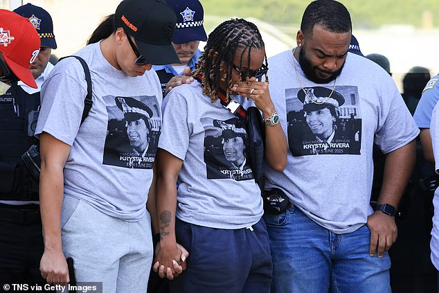 Officers are seen holding hands at a prayer vigil in Rivera's memory