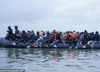 French police watch on as migrants wade into the sea to board UK-bound boats - days after four died in attempted crossing