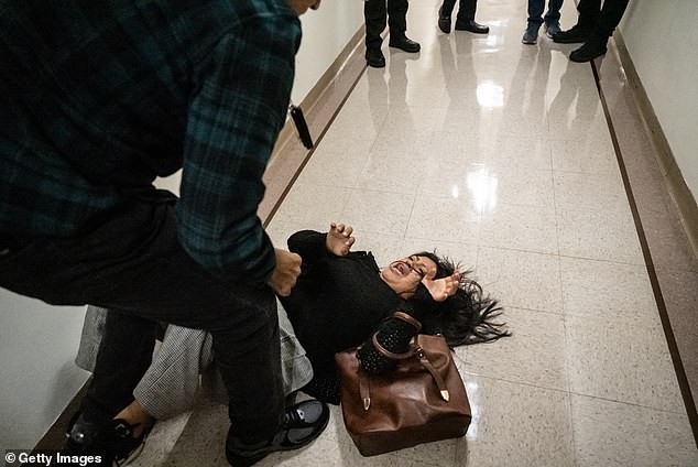 A federal agent pushes the wife of the detained man from Ecuador to the ground on September 25, 2025 in New York City
