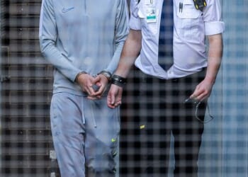 Al-Danasurt grins as he is led to the prison van after court on Wednesday