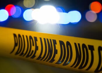 A crime scene at night covered by police tape.