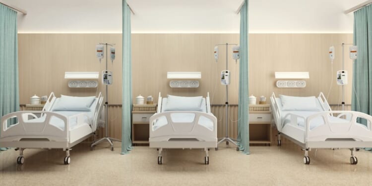 A hospital room with three beds and wooden decoration.