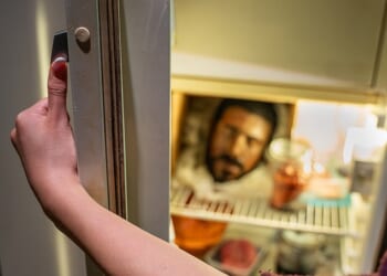 A man's head sits on a shelf in the refrigerator inside the re, a man’s head stares back from a shelf inside
