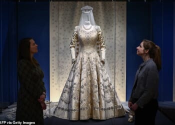 Queen Elizabeth's wedding dress is styled on a mannequin with her 13-foot silk tulle veil and satin sandals, and crowned with Queen Mary's Diamond Fringe Tiara