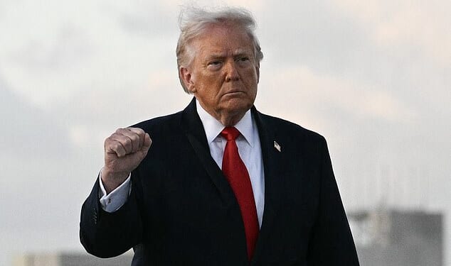 US President Donald Trump makes a fist upon arrival at Miami International Airport in Miami, on April 11, 2026. Trump is traveling to Florida to attend a UFC event and spend the weekend at his Mar-a-Lago residence