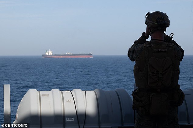 U.S. Central Command posts on April 18, 2026 during the blockade of the Strait of Hormuz: A U.S. Marine aboard the forward-deployed amphibious transport dock ship USS New Orleans (LPD 18) monitors shipping during U.S. maritime blockade operations.