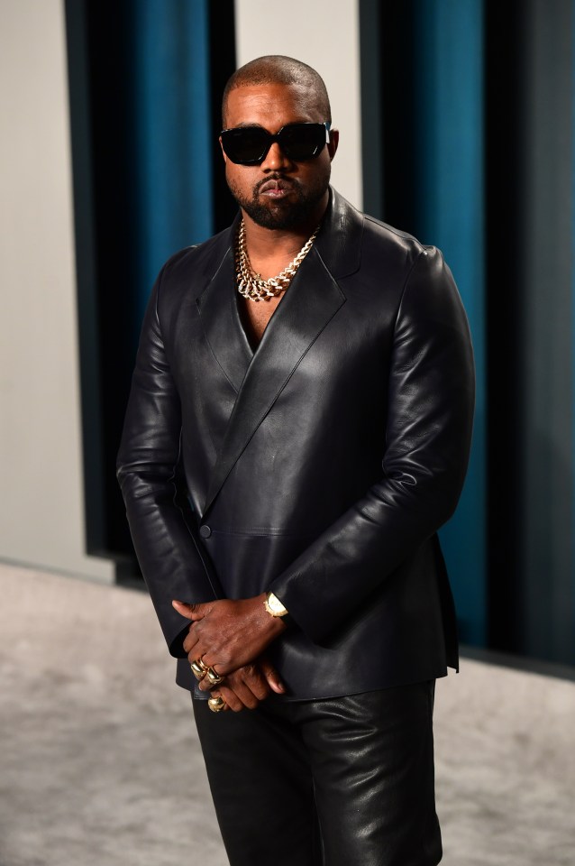 Kanye West wearing a dark leather jacket, sunglasses, and a thick gold chain.