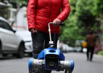 A robot guide dog assists a visually impaired women in Chengdu, China