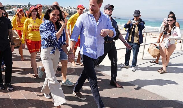 Prince Harry, and Meghan, the Duke and Duchess of Sussex, walk along the boardwalk after meeting volunteer first responders from Bondi Surf Bathers' Life Saving Club, during a visit to Bondi Beach on Friday