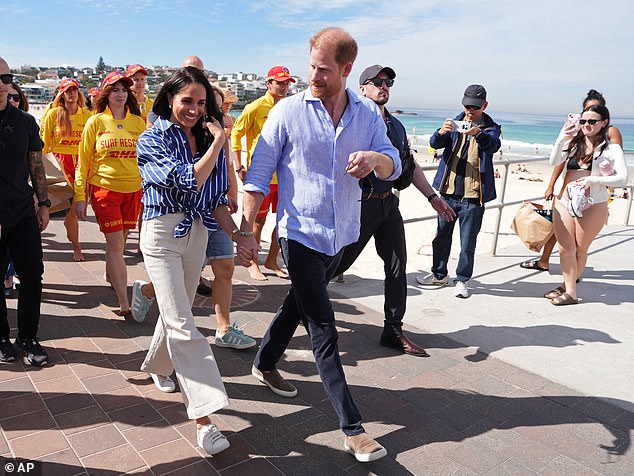 Prince Harry, and Meghan, the Duke and Duchess of Sussex, walk along the boardwalk after meeting volunteer first responders from Bondi Surf Bathers' Life Saving Club, during a visit to Bondi Beach on Friday