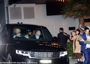 A smiling Meghan leaves the InterContinental Coogee hotel with Harry after being the star guest at an 'ultimate girls' weekend' retreat where guests paid £1,700 to hear her speak and get a photo