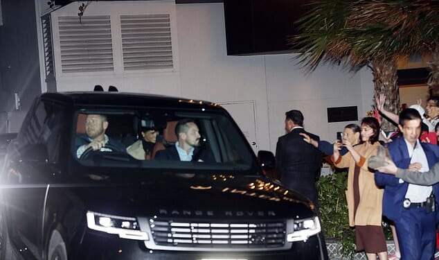 A smiling Meghan leaves the InterContinental Coogee hotel with Harry after being the star guest at an 'ultimate girls' weekend' retreat where guests paid £1,700 to hear her speak and get a photo