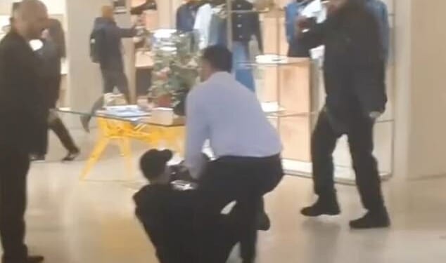 An activist is dragged across the floor during the protest in Louis Vuitton, Bond Street, on Friday