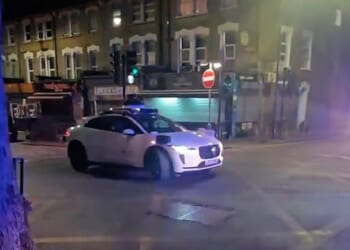 This is the moment a Waymo car drives straight into crime scene tape, narrowly avoiding a police vehicle before coming to a standstill
