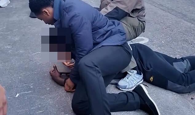 Moment teenage 'shoplifter' is pinned to the road in Mayfair by security guards seconds after 'stealing shoes from nearby shop'